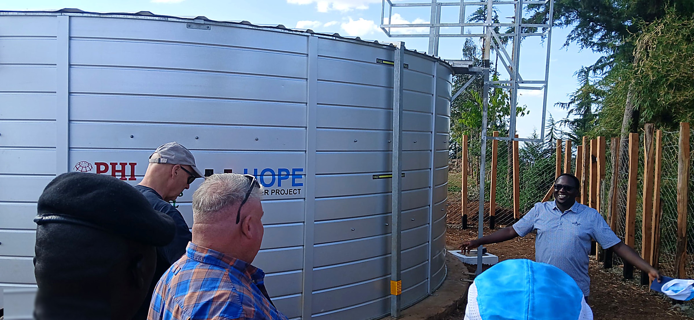 Completed Hope Water Project steel storage tank with partners inspecting the site