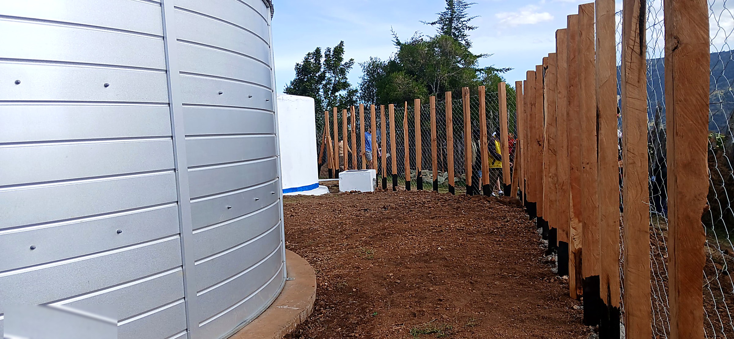 Newly installed perimeter fencing and posts protecting a completed water tank