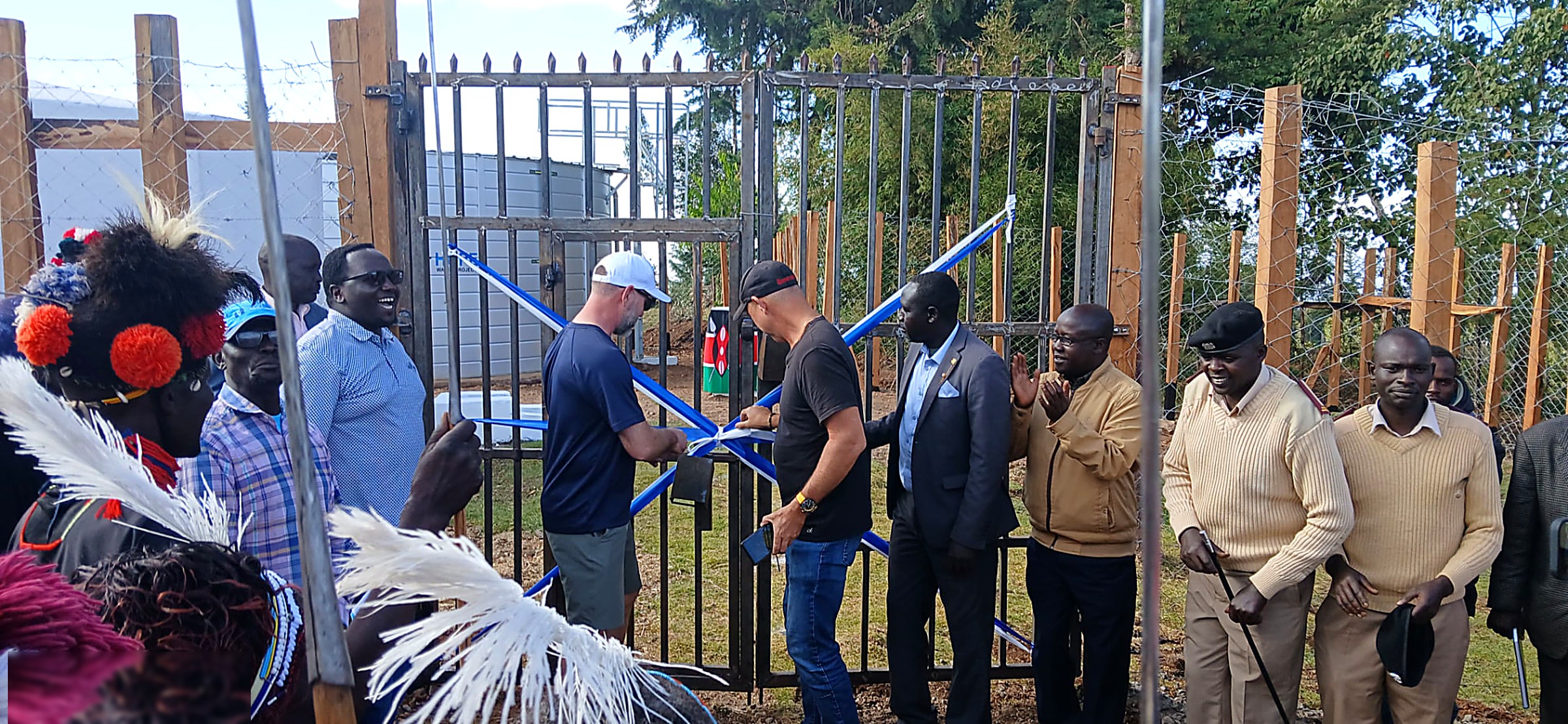 Partners and elders cutting the ribbon at the gate of the Sina water project