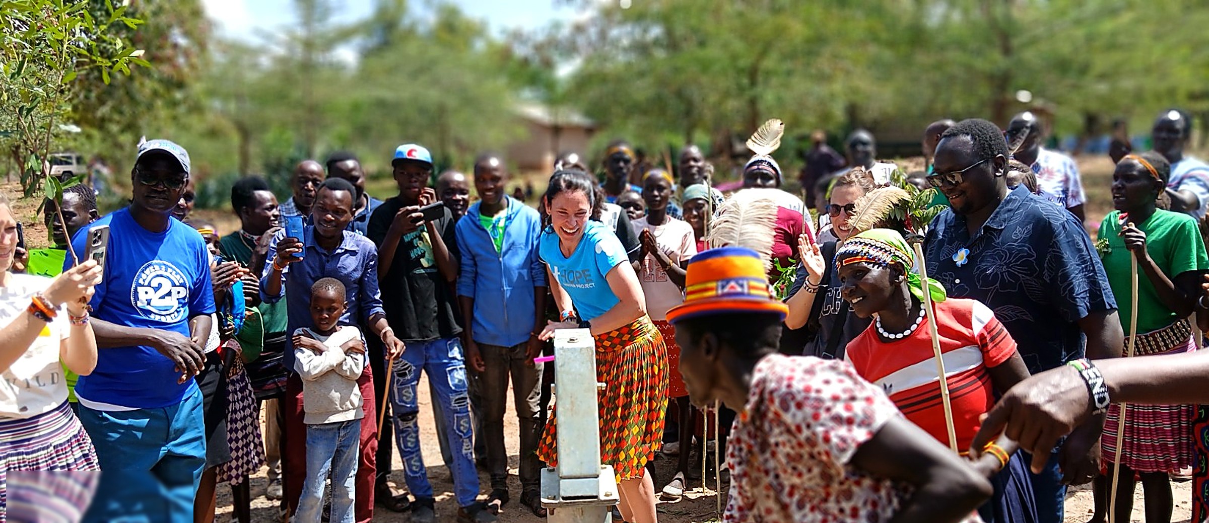 Community members and partners celebrating around a newly commissioned hand pump in West Pokot